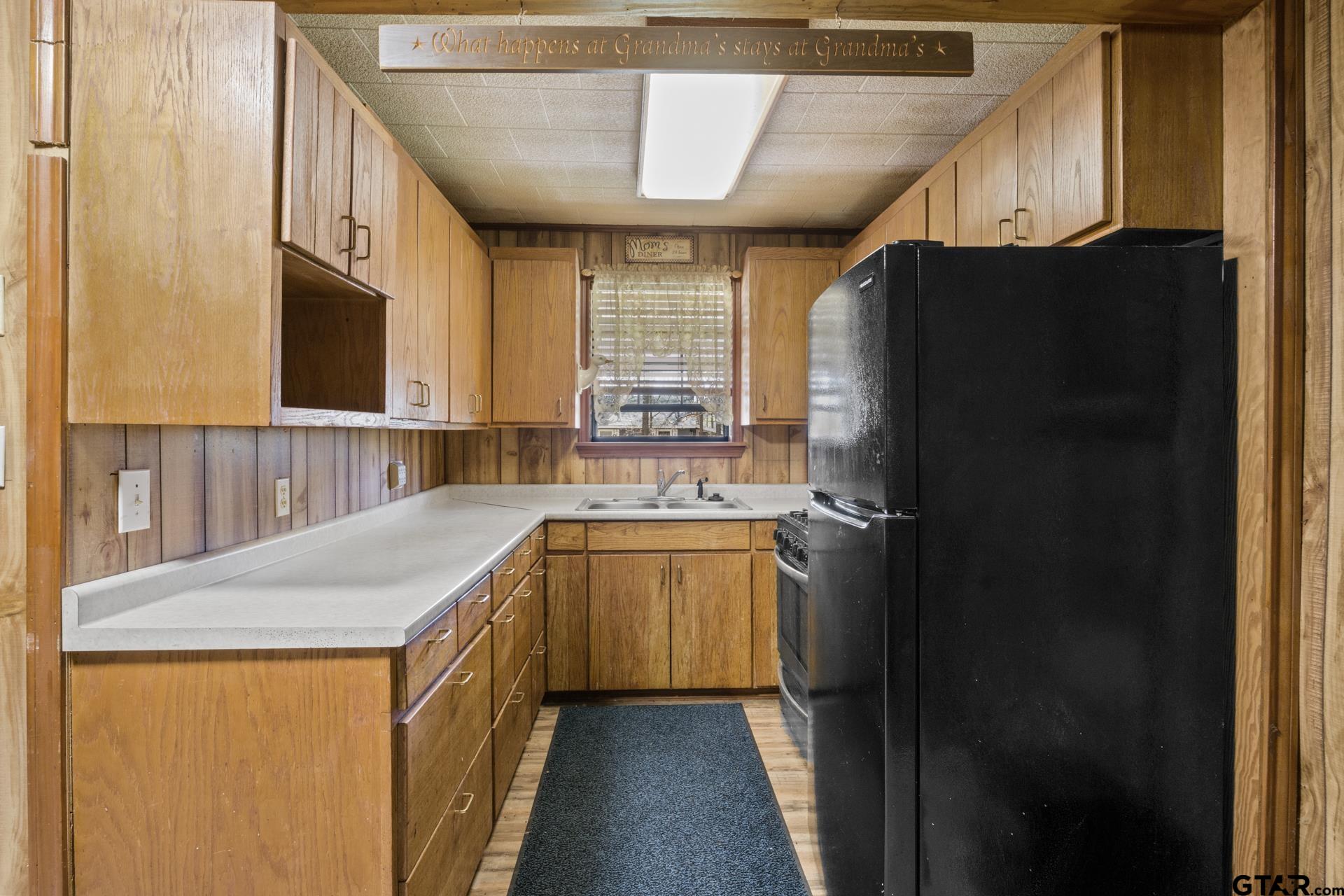 71 Private Road Pittsburg, TX 75686 - Photo 9 of 39 a kitchen with a refrigerator and a sink