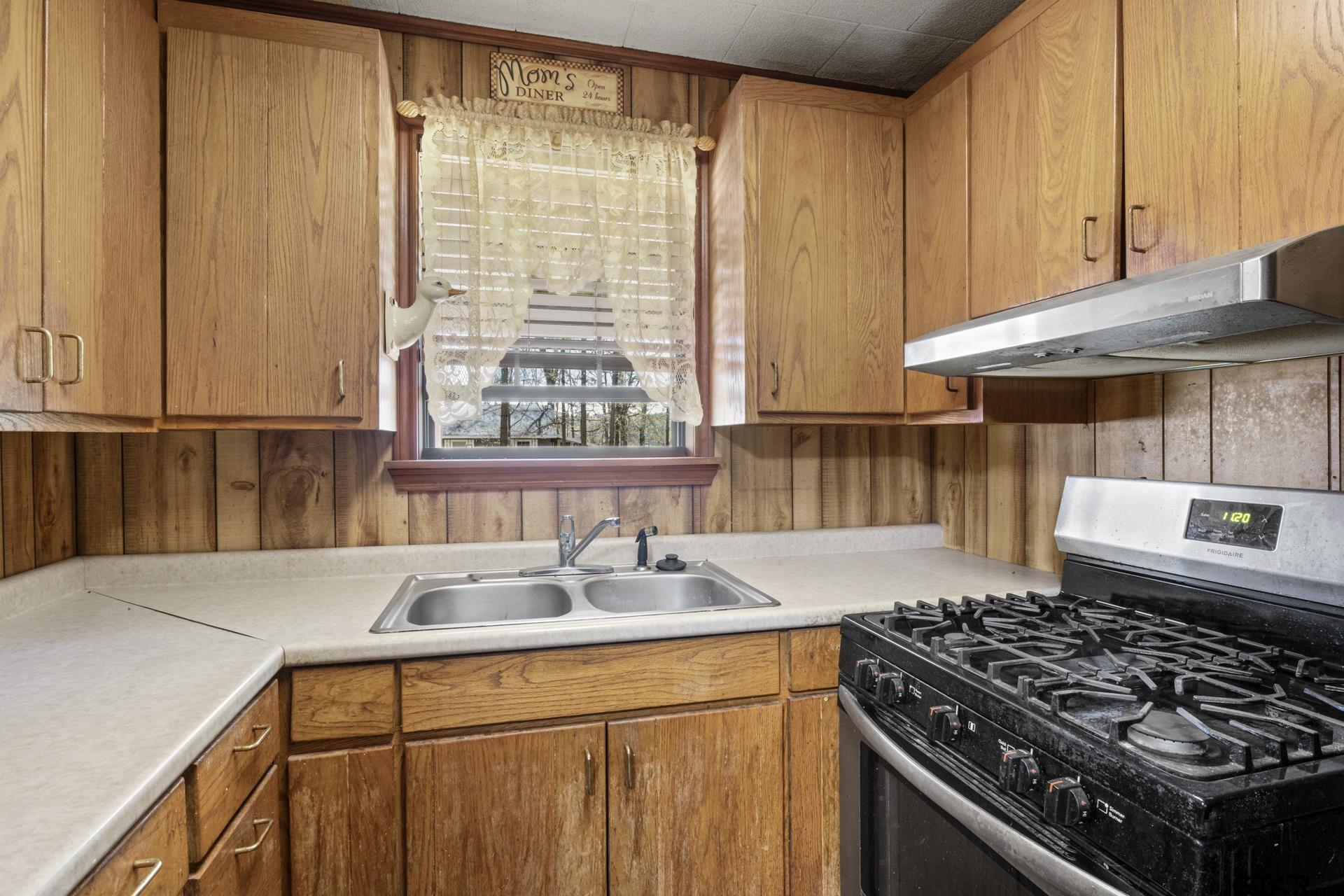71 Private Road Pittsburg, TX 75686 - Photo 10 of 39 a kitchen with a sink a stove cabinets and a window