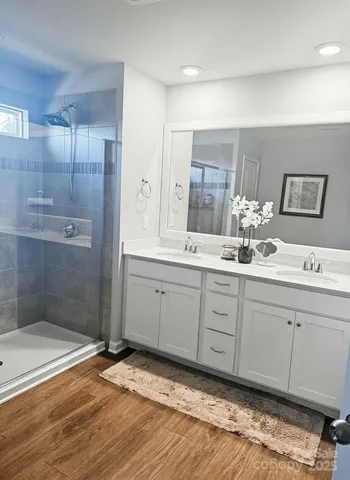 a bathroom with a double vanity sink mirror and shower