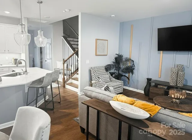 a living room with furniture a flat screen tv and kitchen view