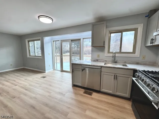 a kitchen with stainless steel appliances granite countertop a stove a sink and a granite counter tops with a large window