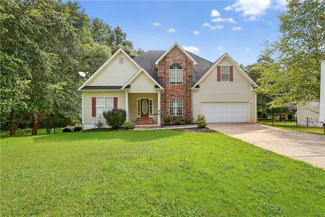 a front view of a house with a yard and trees