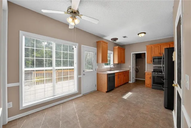 a large kitchen with a large window and stainless steel appliances