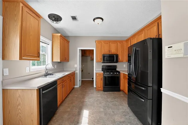 a kitchen with stainless steel appliances granite countertop a refrigerator and a sink