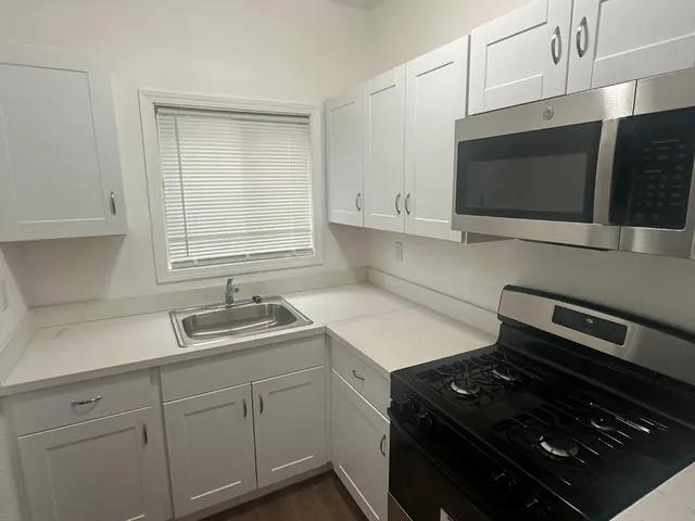a kitchen with a sink stove and microwave