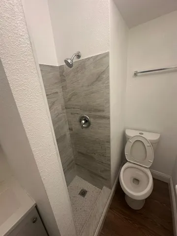 a bathroom with a toilet and a shower