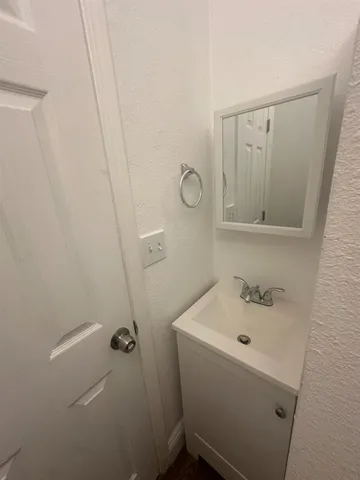 a bathroom with a sink and mirror with toilet