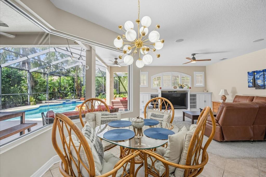 6107 Ibispark Drive Lithia, FL 33547 - Photo 12 of 42 a dining room with furniture a chandelier and large windows
