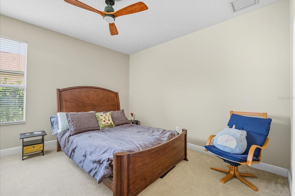 6107 Ibispark Drive Lithia, FL 33547 - Photo 20 of 42 a bedroom with a bed and chair
