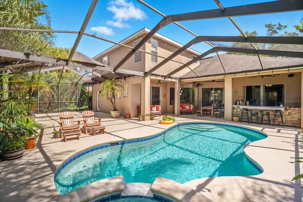 6107 Ibispark Drive Lithia, FL 33547 - Photo 2 of 42 a view of a backyard with table and chairs under an umbrella
