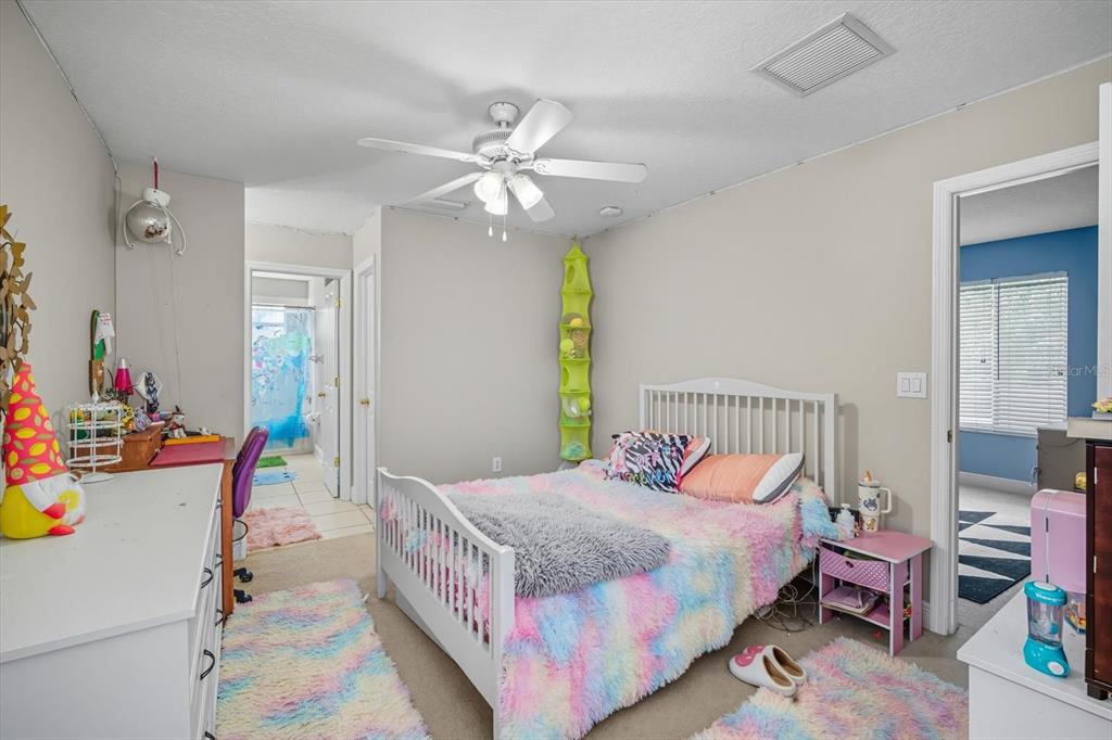 6107 Ibispark Drive Lithia, FL 33547 - Photo 27 of 42 a bedroom with a bed and a chandelier