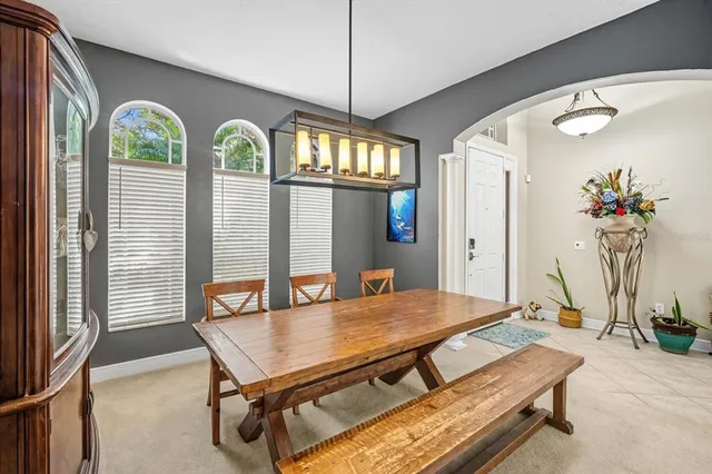 a living room with furniture a chandelier and a floor to ceiling window