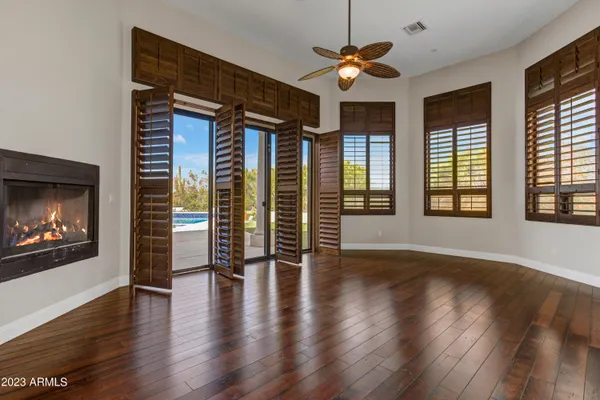 a view of an empty room with a window and wooden floor