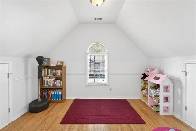 a bedroom with a bed and paintings on the wall