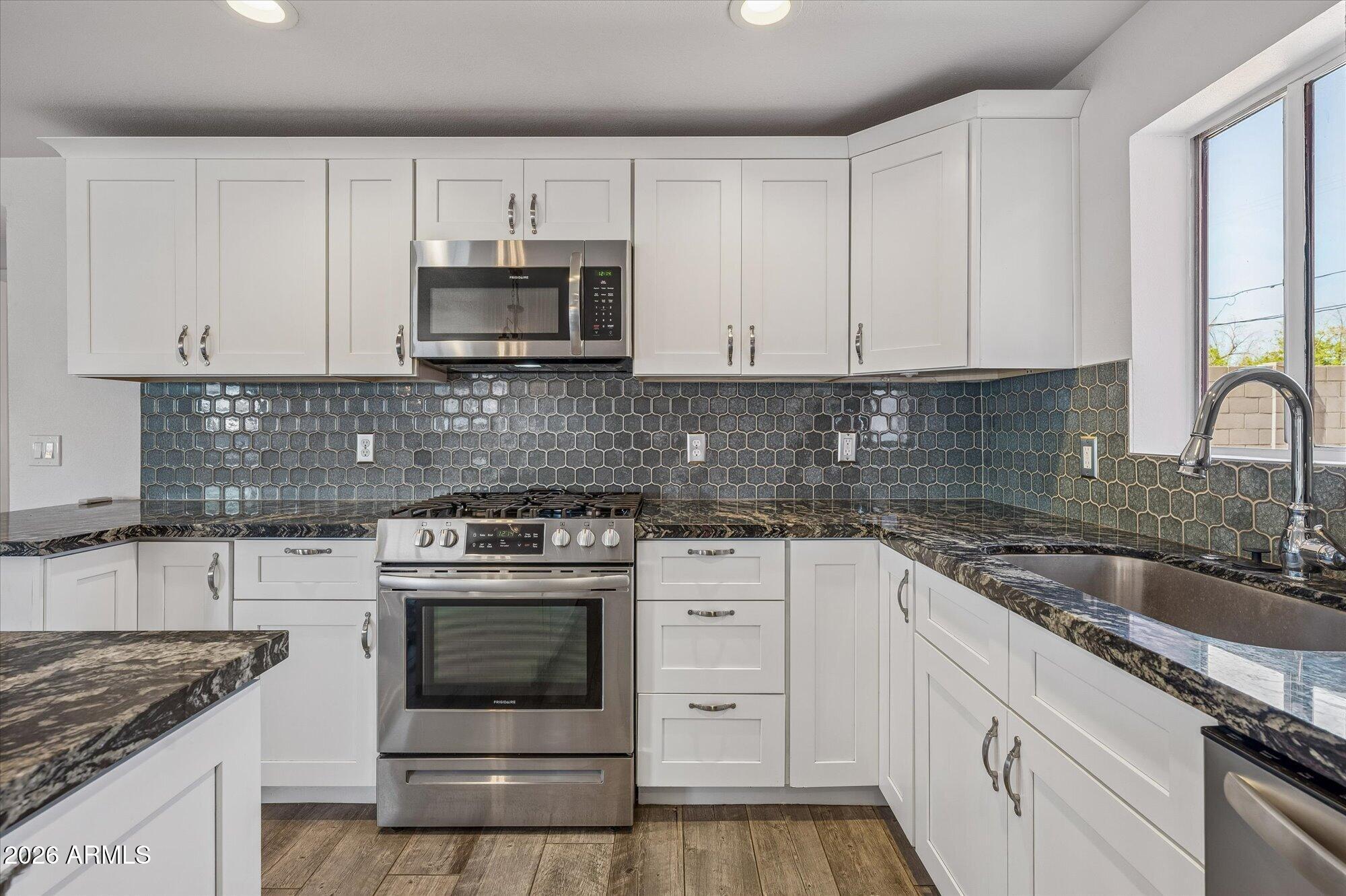 2218 East Yale Street Phoenix, AZ 85006 - Photo 14 of 35 a kitchen with granite countertop white cabinets and stainless steel appliances