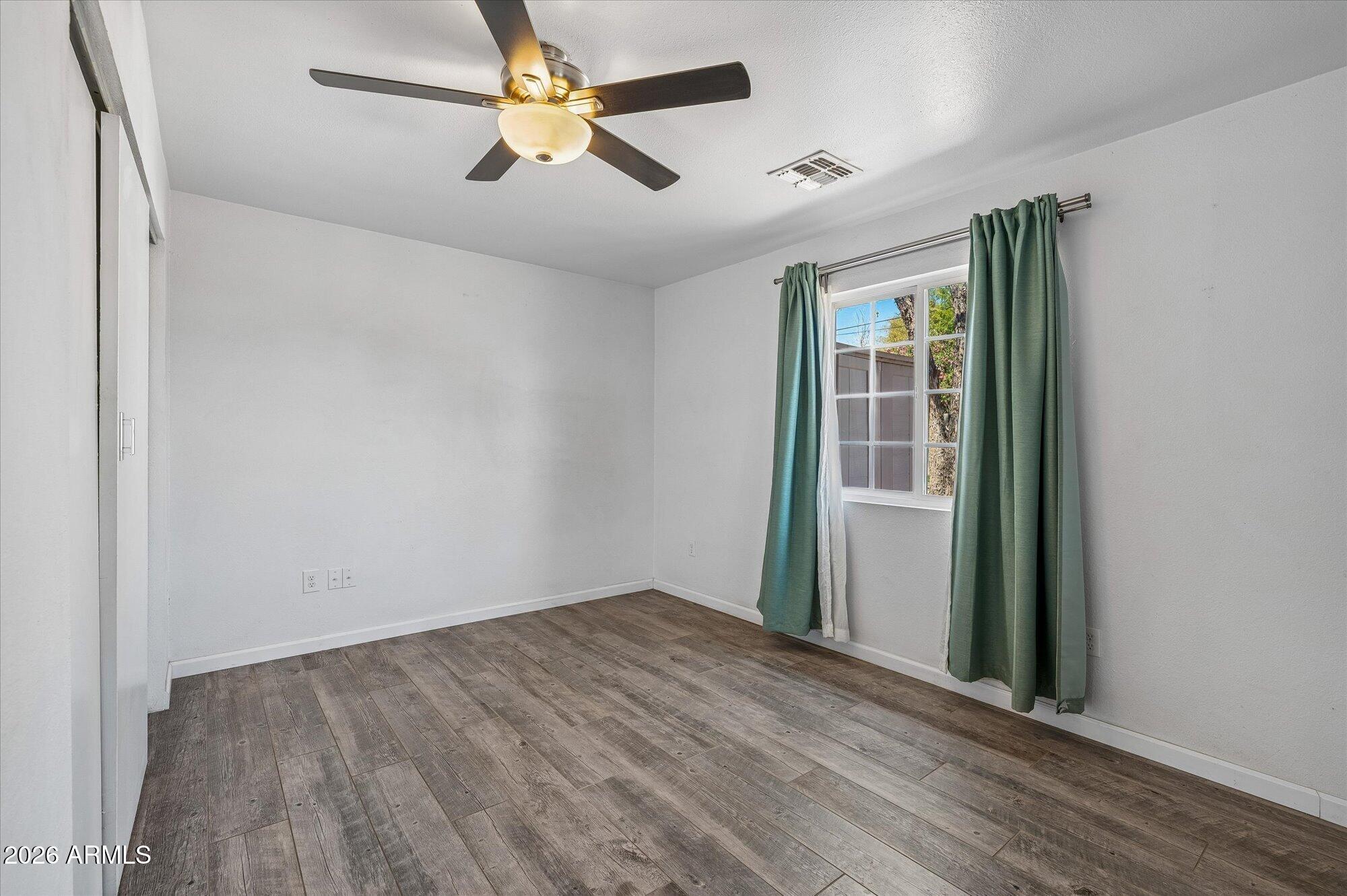 2218 East Yale Street Phoenix, AZ 85006 - Photo 19 of 35 an empty room with wooden floor fan and windows