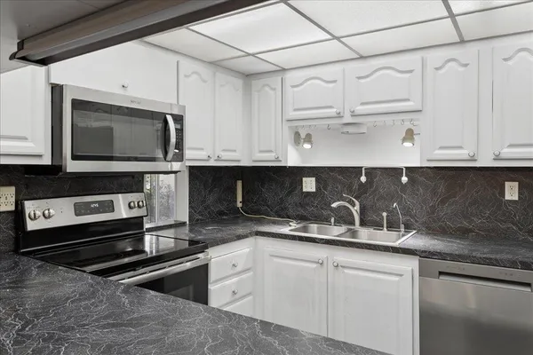 a kitchen with stainless steel appliances granite countertop a sink and a stove