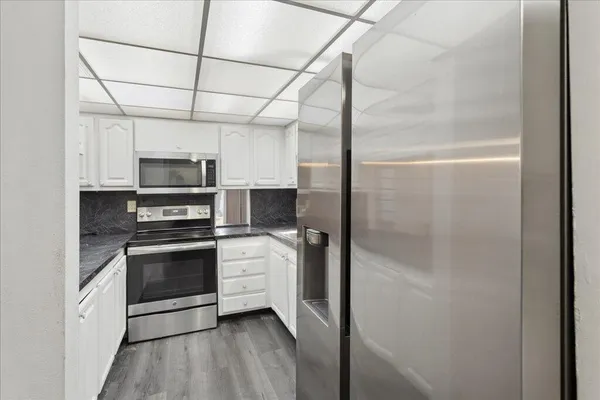 a kitchen with stainless steel appliances a stove a refrigerator and a microwave