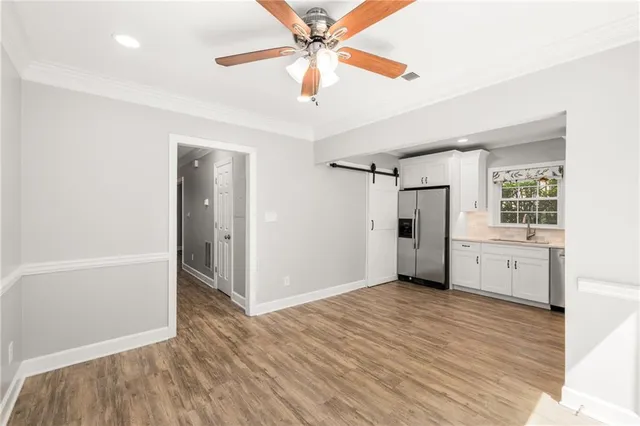 a view of an empty room with window and wooden floor