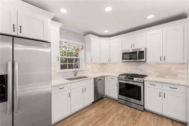 a kitchen with white cabinets and white appliances