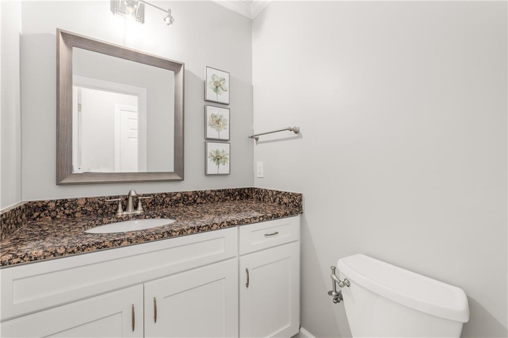 109 Mt Vernon Circle Sandy Springs, GA 30338 - Photo 19 of 37 a bathroom with a granite countertop toilet sink and mirror