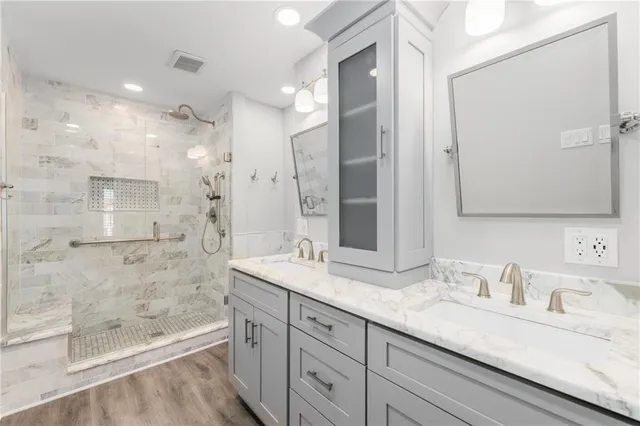 a bathroom with a granite countertop sink mirror and shower