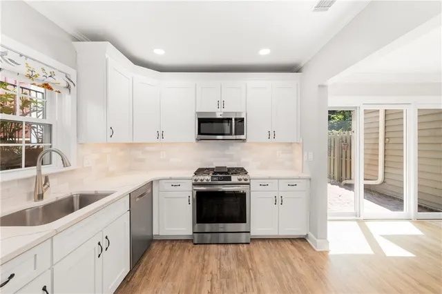 a kitchen with stainless steel appliances a stove a sink and a microwave