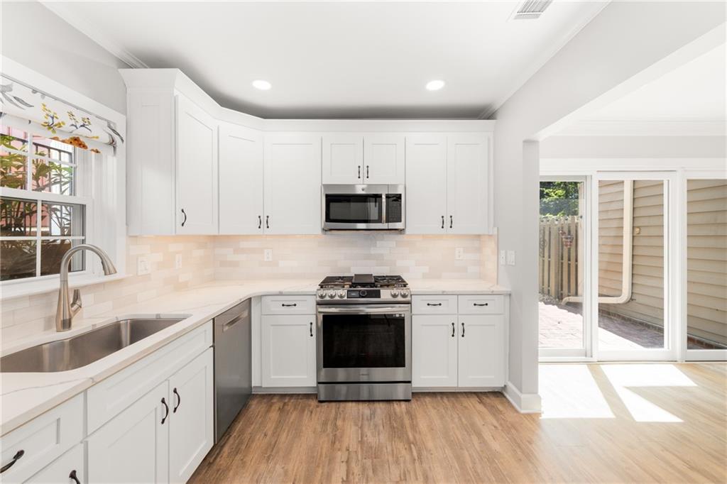 109 Mt Vernon Circle Sandy Springs, GA 30338 - Photo 6 of 37 a kitchen with stainless steel appliances a stove a sink and a microwave