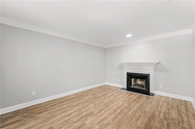 a view of empty room with wooden floor and fireplace