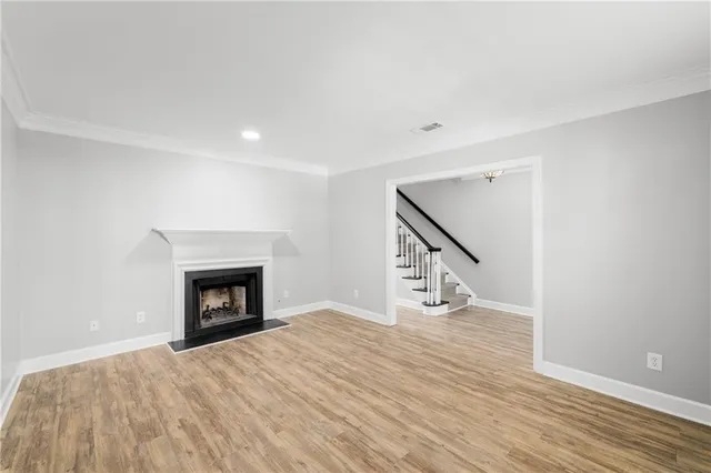 a view of empty room with wooden floor and fireplace