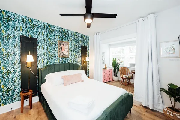 a bed room with a bed mirror and a table