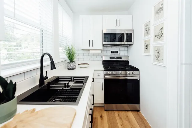 a kitchen with a sink a stove and microwave