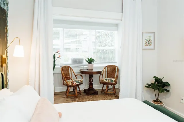 a dining room with furniture and potted plants