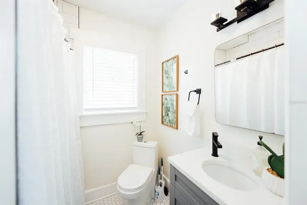 a bathroom with a sink a toilet and a mirror