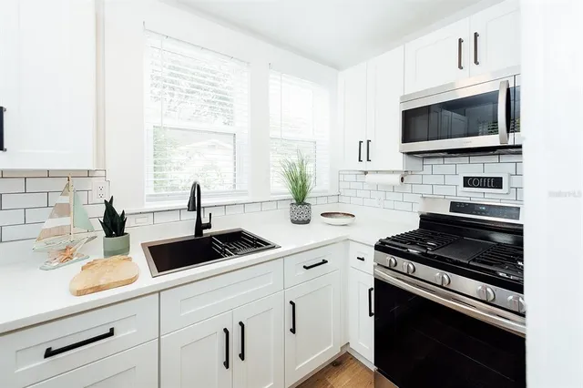 a kitchen with a sink stove and microwave