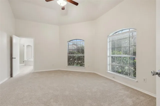 an empty room with chandelier fan