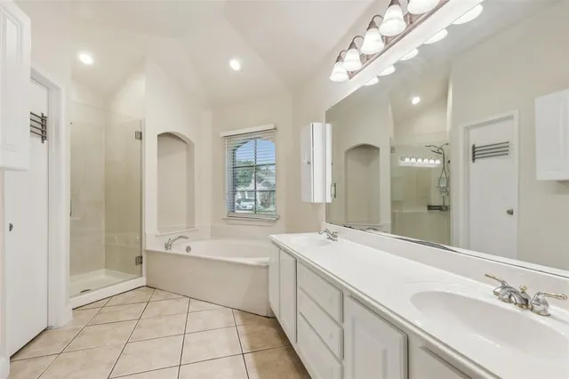 a bathroom with a tub a sink shower and a mirror