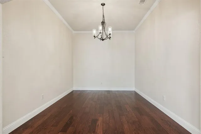 a view of a room with wooden floor chandelier and entryway