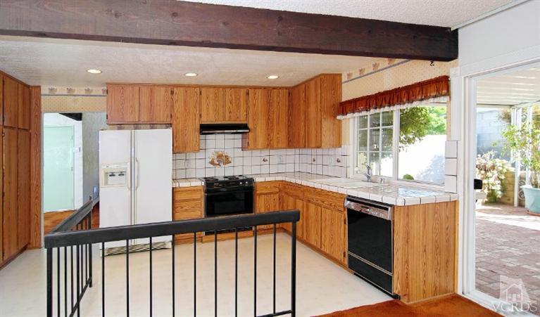 2796 Harrington Road Simi Valley, CA 93065 - Photo 12 of 15 a kitchen with stainless steel appliances granite countertop a refrigerator a sink dishwasher a stove and white countertops with wooden floor