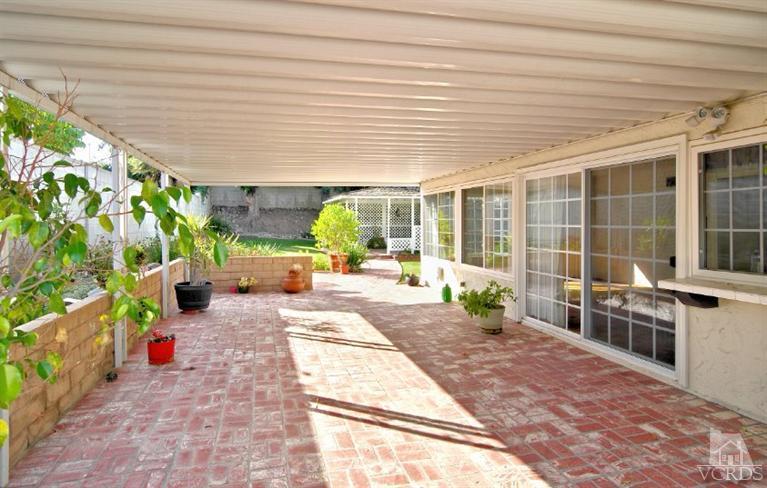 2796 Harrington Road Simi Valley, CA 93065 - Photo 3 of 15 a porch with a table and chairs and potted plants