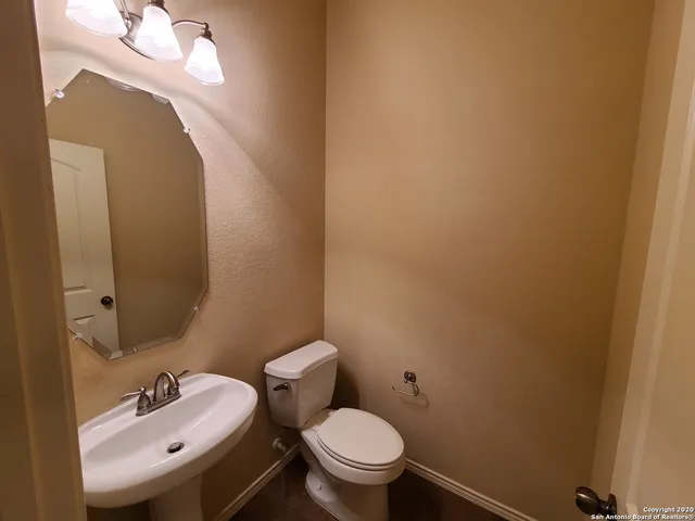 a bathroom with a sink a toilet and a mirror