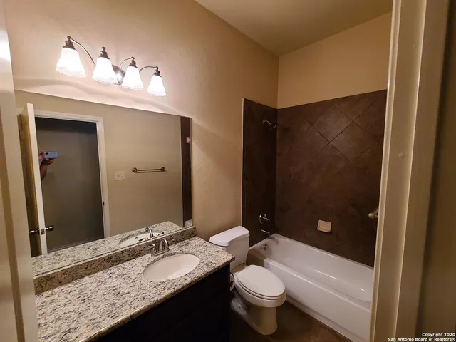 a bathroom with a granite countertop sink toilet and shower