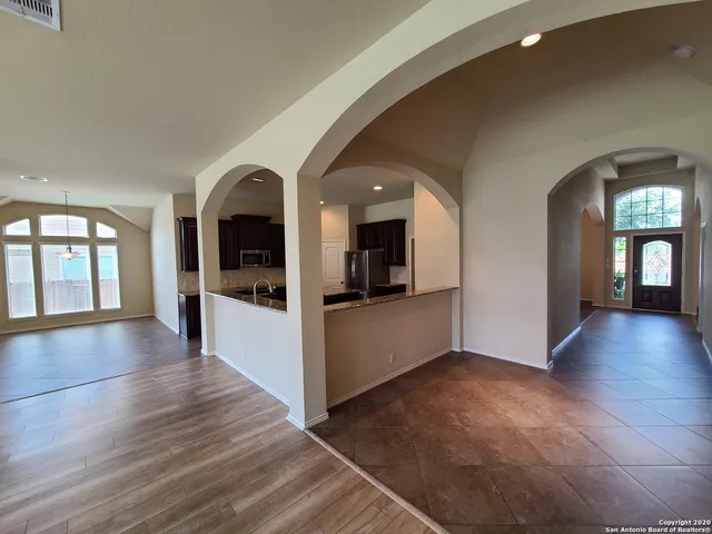 a view of a living room with kitchen view and wooden floor