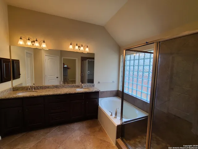 a bathroom with a tub sink and mirror