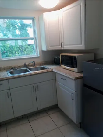 a kitchen with white cabinets and a sink