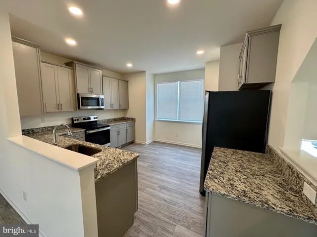 a kitchen with kitchen island sink and refrigerator