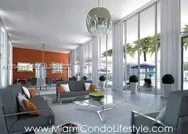 a living room with furniture and floor to ceiling windows