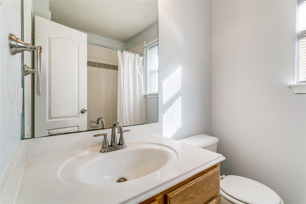 2408 Graystone Lane Corinth, TX 76210 - Photo 15 of 17 a bathroom with a sink a toilet and tub