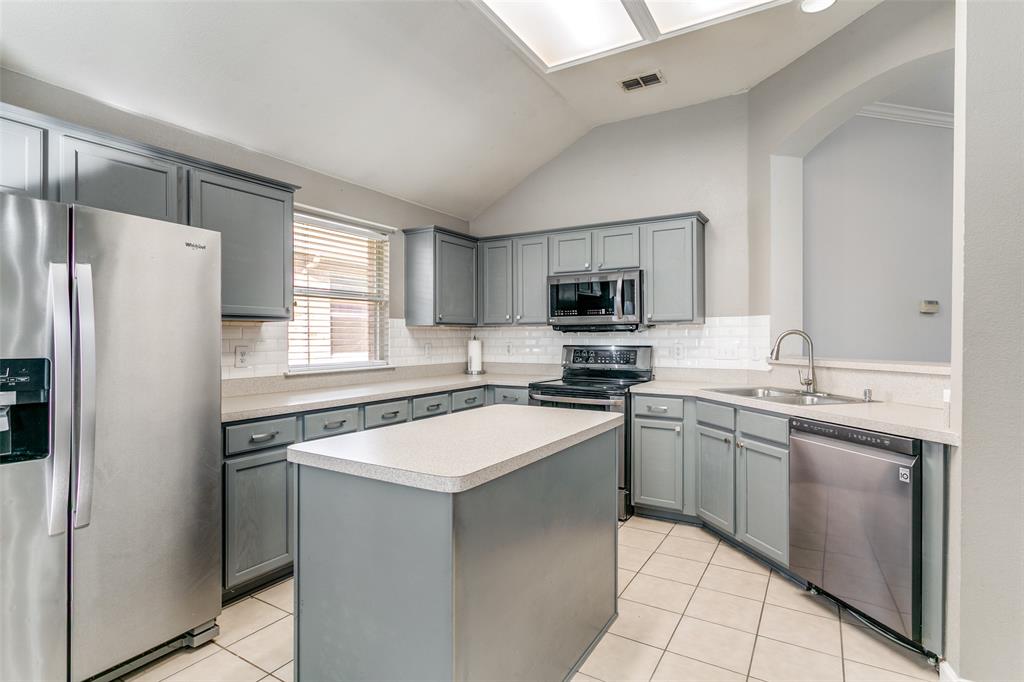 2408 Graystone Lane Corinth, TX 76210 - Photo 4 of 17 a kitchen with stainless steel appliances granite countertop a refrigerator sink and stove