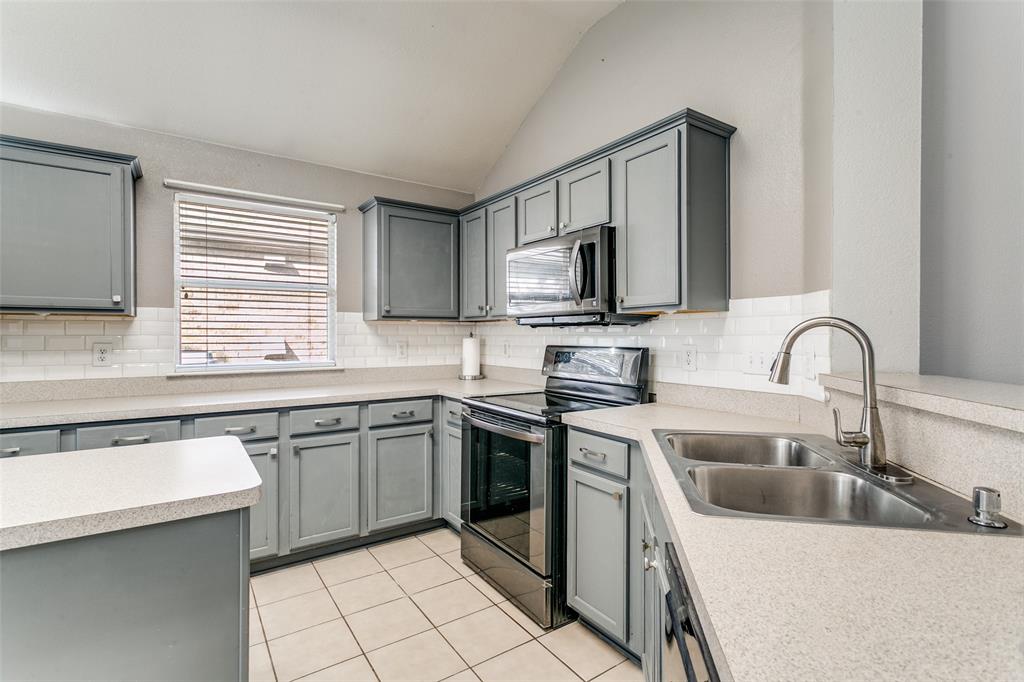 2408 Graystone Lane Corinth, TX 76210 - Photo 5 of 17 a kitchen with stainless steel appliances granite countertop a sink and stove top oven
